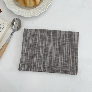 Detailed texture of gray cotton linen placemat with white vertical stripes on marble surface