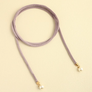 Detail of light purple velvet choker with white pearls and gold metal accents