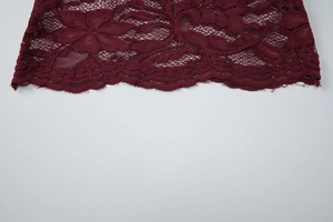 Vista macro dettagliata del pizzo floreale bordeaux con intricati motivi traforati