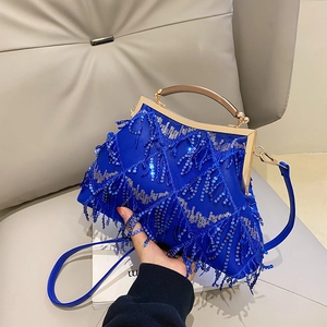 Detail of blue sequined evening bag with tassel beads and golden metal handle