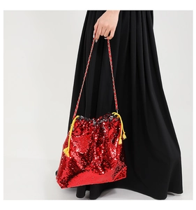 Detail of red sequined bucket bag with gold chain strap and yellow tassel drawstring