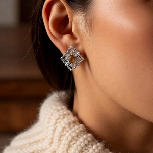 Close-up of retro hollow diamond-shaped earring with tiger eye stone on model