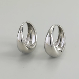 Macro detail of high-polished S925 sterling silver teardrop earrings with hallmark