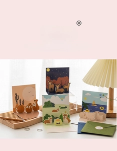 Detail of 3D pop-up animal greeting cards with fox, elk, and corgi on a wooden tray