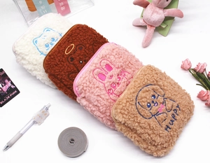 Detailed embroidery on plush animal-themed storage bags with teddy fleece texture
