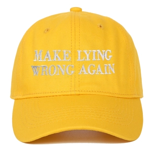Dettaglio del ricamo bianco Make Lying Wrong Again sul cappellino in cotone giallo