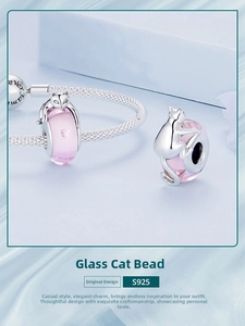 Macro shot of S925 silver pink glass cat beads on a silver mesh bracelet