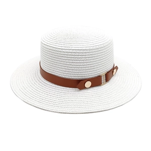 Detail of white woven boater straw hat featuring a brown leather band and gold buttons
