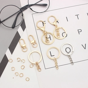 Mix of gold and silver metal lobster clasps and key rings displayed on a textured surface
