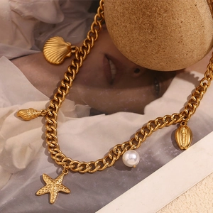 Detail of 18K gold-plated necklace with seashell, starfish charms and a pearl