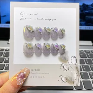 Detailed view of handmade purple glitter press-on nails with luxury rhinestone embellishments