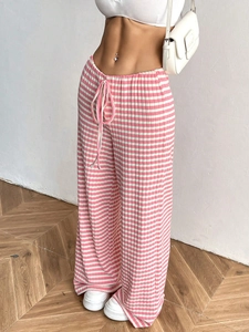 Detail of pink and white striped wide-leg trousers with elastic drawstring waist for women