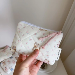 Close-up of quilted floral coin purse with cute bear pattern and simple wish label