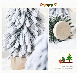 Detail of snowy mini Christmas tree with realistic flocking and natural wood base