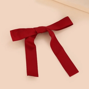 Detailed view of the dark red ribbon bow hair clip with elegant satin fabric texture