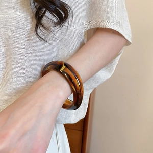 Detailed macro view of retro amber resin bangle featuring thick translucent marble texture