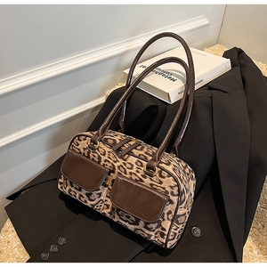 Detail of leopard print suede shoulder bag with dual front pockets on a black blazer