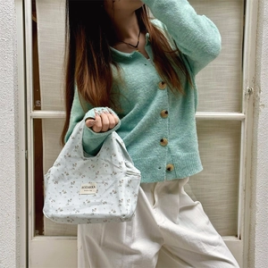 Floral canvas lunch bag with side pockets shown in a daily commute scene
