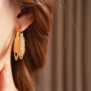Elegant gold plated chain hoop earrings with cubic zirconia stones worn by model