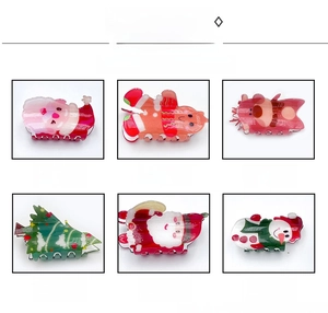 Close-up of festive Christmas acrylic hair claws featuring gingerbread man and reindeer