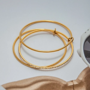 Detail of three-piece gold-plated zircon bangles with smooth and micro-pave diamond designs