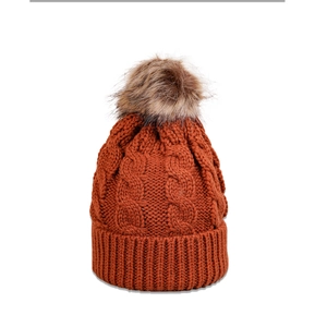 Detail of cable knit beanie featuring a fluffy faux fur pompom and wide ribbed cuff