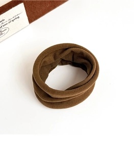 Close-up of coffee brown velvet hair tie with soft pleated texture and elastic design