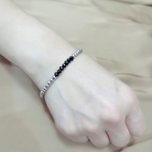 Detail of beaded bracelet with polished silver steel beads and faceted black crystals