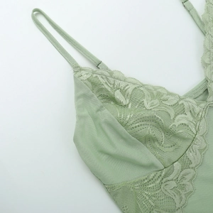 Close-up of light green lace camisole showing floral mesh patterns and adjustable straps