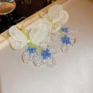 Detailed view of handmade beaded flower earrings with light blue crystals and sheer fabric