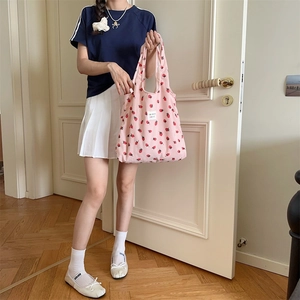 Détail de la texture en velours côtelé rose avec imprimé fraise sur un cabas
