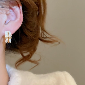 Close-up of bow knot stud earring with 18k gold plating and sparkling rhinestones