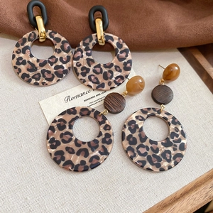 Detailed view of leopard print resin earrings with acrylic and wooden accents