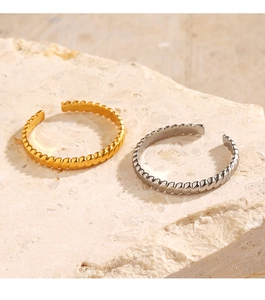 Macro detail of 18K gold and silver plated twisted rope rings on natural stone