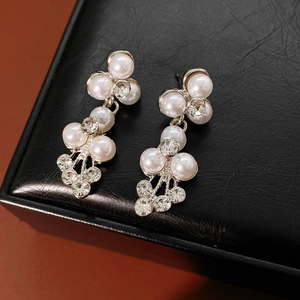 Détail de boucles d'oreilles de mariée avec perles et cristaux sur boîte en cuir