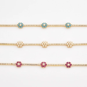 Close-up of gold-plated tennis chain with colorful flower charms and zircon inlay