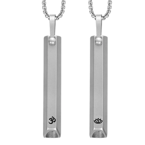 Detail of meditation whistle necklace with engraved Om and lotus symbols on silver steel