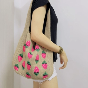 Beige knitted strawberry tote bag worn by a model for a casual aesthetic look