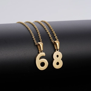 Gros plan des pendentifs numéros 6 et 8 dorés avec finition métallique polie sur un collier