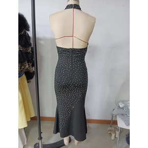Detail of backless design and sparkling rhinestones on a black halter evening gown
