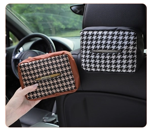 Detail showing brown houndstooth tissue box with leather trim hanging on car headrest