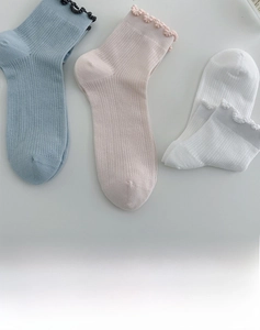 Detail of cotton crew socks with vertical ribbing and delicate ruffle lace edge trim