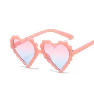 Pink heart-shaped glitter sunglasses for kids with scalloped edges and gradient lenses