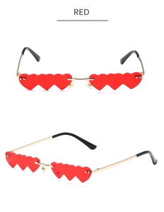 Detail view of red heart-shaped rimless sunglasses with elegant gold metal temples