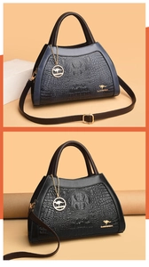 Close-up of crocodile pattern handbags in gradient blue and black with gold hardware
