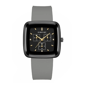 Macro detail of square black quartz watch face with gold markers and grey silicone strap