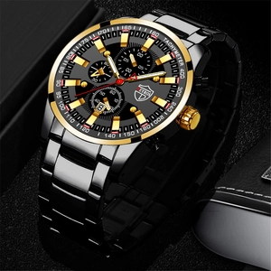 Detail of black quartz watch with gold bezel featuring date window and chronograph dial