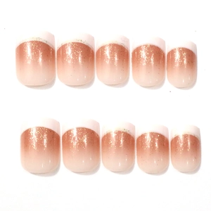 Detail of nude pink French gradient press-on nails with glitter tips and golden sequins