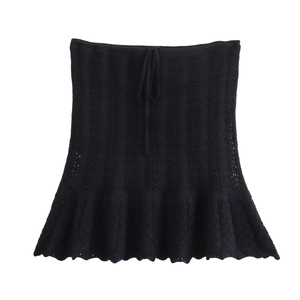 Dettaglio gonna in maglia nera con motivi traforati e coulisse in vita