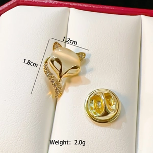 Detail of fox-shaped brooch in gold finish with opal and diamond inlay in a gift box